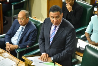 Prime Minster, the Most. Hon. Andrew Holness, pays respects to Her Majesty, The Queen, during Tuesday’s (September 13) sitting of the House of Representatives. Beside him is Deputy Prime Minister and Minister of National Security, Hon. Dr. Horace Chang.

