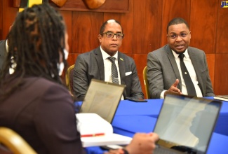 Minister without Portfolio in the Office of the Prime Minister (OPM), with responsibility for Information, Hon. Robert Morgan (right), makes a point while addressing members of the Youth Advisory Council, during a meeting at Jamaica House in St. Andrew, on September 27. At second right is  Minister of State in the Ministry of Industry, Investment and Commerce, Dr. the Hon. Norman Dunn.
