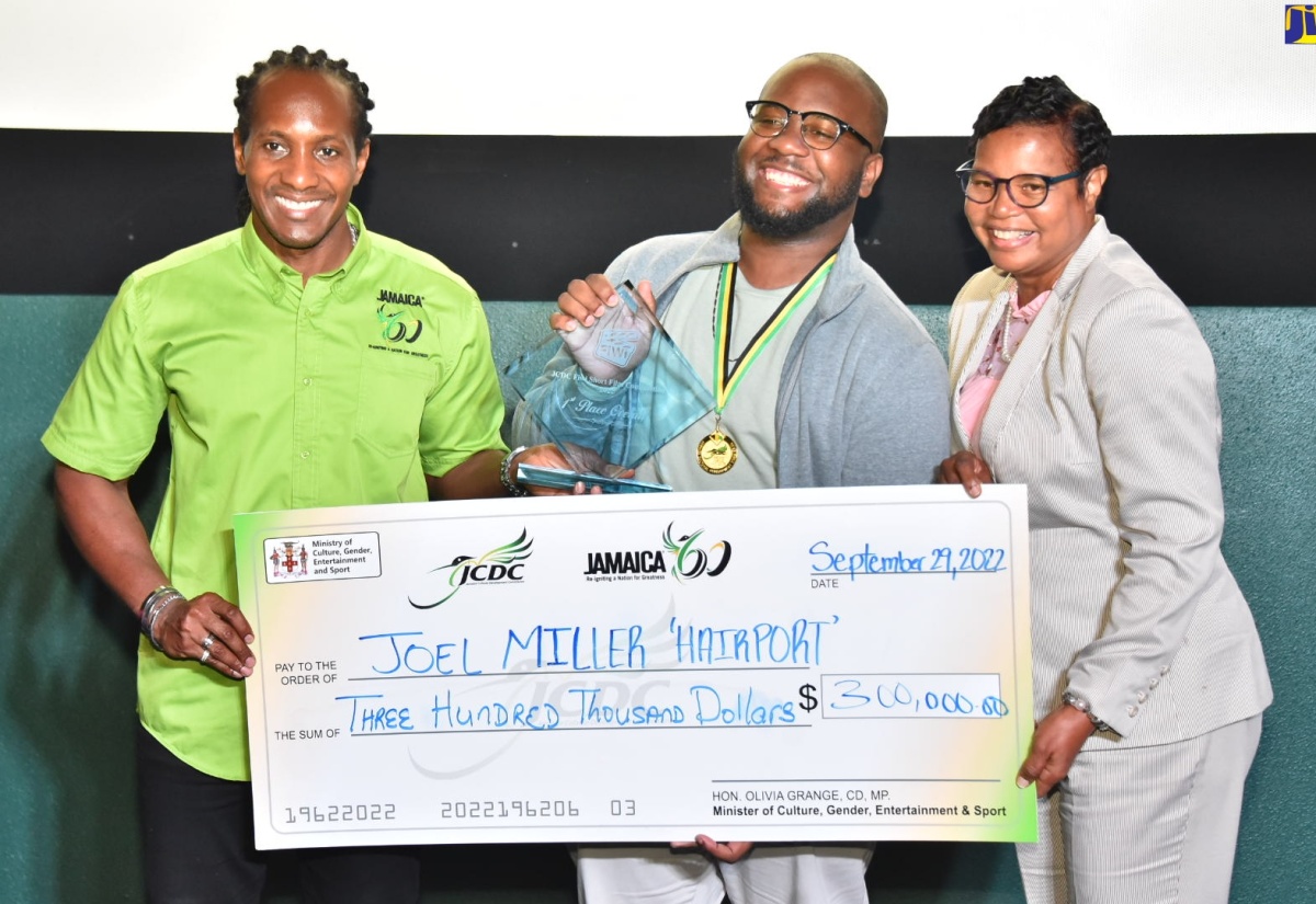 Minister of State in the Ministry of Culture, Gender, Entertainment and Sport, Hon. Alando Terrelonge (left), presents George Malcolm Walker (centre), who represented Joel Miller, with an award for first place for the film ‘Hairport’, during an awards ceremony for the 2022 FiWi Short Film Competition, held on September 29, at the Palace Cineplex in Sovereign Centre, St. Andrew.  At right is Acting Executive Director, Jamaica Cultural Development Commission (JCDC), Marjorie Leyden-Kirton. The FiWi Short Film Competition is a brainchild of the JCDC’s Drama and Theatre Arts Unit, which encourages Jamaican amateur filmmakers to examine one of five selected Jamaican proverbs and create a short film treatment, based on their interpretation. This year marks the second staging of the competition, which started in 2021.