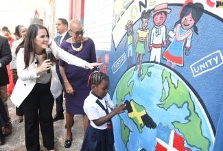 Minister of Education and Youth, Hon. Fayval Williams (right), looks on as Ambassador of the Dominican Republic, Her Excellency Angie Martinez (left), explains the significance of the mural that was unveiled at the Franklin Town Primary School in Kingston, which has been adopted by the Embassy of the Dominican Republic. Also looking on is student, Khalia Evans. The mural was part of the facelift gifted to the school by the Embassy  and represents friendship between the two countries. The ceremony was held on Monday, September 5.

