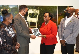 Prime Minister, the Most Hon. Andrew Holness (second left), accepts a catalogue of the exhibition -‘Kingston Biennial 2022: Pressure’ - from Senior Director of the National Gallery of Jamaica (NGJ), Roxanne Silent (second right), following his tour of the display at the NGJ on Thursday (September 8). Looking on (from left) are Minister of Culture, Gender, Entertainment and Sport, Hon. Olivia Grange,  and Chief Curator, NGJ, O’Neil Lawrence.