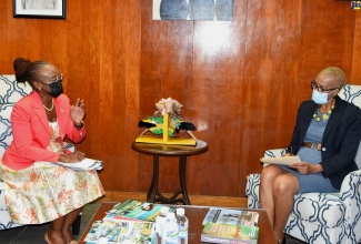 Minister of Education and Youth, Hon. Fayval Williams (right), converses with US Peace Corps Jamaica Country Director, Glenda Green, during a courtesy call to the Ministry’s Kingston offices on Wednesday (August 31). 