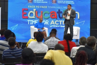 Prime Minister, the Most Hon. Andrew Holness (standing), addresses a townhall meeting at Jamaica College, in St. Andrew, on Friday (September 9). Seated is Education and Youth Minister, Hon. Fayval Williams. The meeting was organised by the Office of the Prime Minister (OPM).

