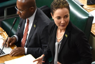 Leader of Government Business in the Upper House and Minister of Foreign Affairs and Foreign Trade, Senator the Hon. Kamina Johnson-Smith, pays tribute to The Queen, during Friday’s (September 9) sitting of Senate at Gordon House. Seated is Minister of Industry, Investment and Commerce, Senator the Hon. Aubyn Hill.

