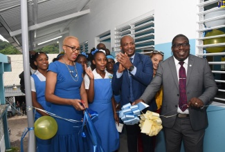 Education and Youth Minister, Hon. Fayval Williams (left), cuts the ribbon to officially open a new classroom block at Edwin Allen High School in Frankfield, Clarendon, on October 7. Participating in the ceremony are Principal, Jermaine Harris (third left); Education Officer Region 7, Ministry of Education and Youth, Errol Haughton (right); along with several students. The project was managed and implemented by the National Education Trust (NET) under the Ministry of Education and Youth’s Primary and Secondary Infrastructure Project (PSIP).