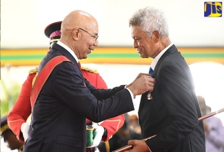 Governor-General, His Excellency the Most Hon. Sir Patrick Allen, presents the Order of Distinction in the Rank of Officer (OD) to Douglas Anthony Richard Russell, in recognition of his contribution to the sport of tennis locally, at the National Honours and Awards Ceremony held at King’s House on October 17.