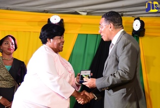 Prime Minister, the Most Hon. Andrew Holness (right) presents  Regional Director of the Ministry of Education and Youth – Region Four, Dr. Michelle Pinnock, with the Prime Minister’s Medal of Appreciation for Service to Education during a ceremony held at Jamaica House, recently. 

