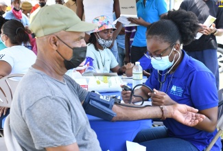 Nurse at the Diabetes Association of Jamaica, Deborah Dawes (right), conducts a blood-pressure check on 66-year-old tractor operator, Denham Ranken, during a health fair hosted by the Westmoreland Health Department on the grounds of the Pan Caribbean Sugar Factory at Frome in the parish on September 27. 