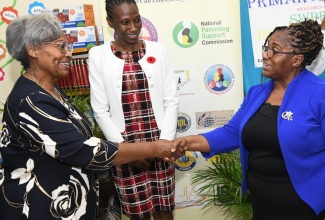 Member of the Jamaica Character Education Task Force and Founding Chief Executive Officer of Ontario Literacy and Numeracy Secretariat, Dr. Avis Glaze (left) greets Principal of Rousseau Primary School, Viviene Anderson (right), during her visit to the institution in Kingston on Tuesday, (October 18). Looking on is National Coordinator for Character Education, Simone Foster. 