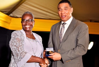 Prime Minister’s Medal of Appreciation awardee, retired Educator, Carmen Louise Samuels (left), receives her medal from Prime Minister, the Most Hon. Andrew Holness (right), in recognition of her 30 years of outstanding service to education, at the awards presentation ceremony, held at Jamaica House on Thursday, September 8.

