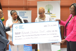 Minister of Education and Youth, Hon. Fayval Williams (second right), and National Education Trust Limited (NET) Donor and Partnership Officer, Simone Griffith right), receive a cheque in the sum of $254,168.95 from the Jamaica Social Stock Exchange (JSSE) for the Ministry’s ‘One Tablet or Laptop Per Child’ initiative. Making the presentation are Group Business Development Manager, Jamaica Stock Exchange (JSE), André Gooden (left), and JSSE Manager, Nora Blake.