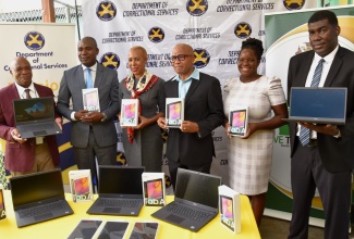 Education and Youth Minister, Hon. Fayval Williams (third left), displays one of the laptops and tablets donated by E-Learning Jamaica (e-LJam) Limited to the Department of Correctional Services (DCS), South Camp Juvenile Correctional Centre in Kingston on October 4. Others taking part (from left) are Commissioner of Corrections, Col. (Retd) Gary Rowe; Minister of State in the Ministry of National Security, Hon. Zavia Mayne; Chief Executive Officer (CEO), e-Learning Jamaica Company Limited (e-LJam), Andrew Lee; Principal Director, Information and Communications Technology (ICT), Ministry of Science, Energy and Technology, Kaydian Smith Newton; and Deputy Commissioner, Rehabilitation and Probation Aftercare Services, DCS, Dr. Marc Thomas. 