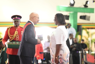 Governor-General, His Excellency the Most Hon. Sir Patrick Allen, says a few words to Bursar at Clarendon College, Theda Falconer Brooks, as he presents her with the Badge of Honour for Long and Faithful Service to the education sector, during the National Honours and Awards ceremony, held recently at King’s House in Kingston.