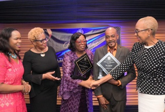 Minister of Education and Youth, Hon. Fayval Williams (right), greets retirees of the Ministry Sharon Whyte (centre), and Erie Gooden (second right), during a retirement awards banquet at the Jamaica Pegasus Hotel in New Kingston, on Thursday (November 3). Sharing the moment (from left) are Acting Chief Education Officer, Dr. Kasan Troupe, and Acting Permanent Secretary, Maureen Dwyer. 