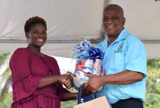 Minister of State in the Ministry of Agriculture and Fisheries, Hon. Franklin Witter (right), presents second runner-up in the ‘Many Moods of Tilapia’ cooking competition, Camelia Thompson, with her prizes. Occasion was the Eat Jamaican Day Expo at Devon House on November 25.