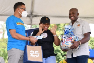 Minister of Agriculture and Fisheries, Hon. Pearnel Charles Jr. (right), and Rainforest Caribbean’s Roger Lyn (left), present an overjoyed Sasha-Kay Gooden-Petrie with her prizes for copping first place in the inaugural ‘Many Moods of Tilapia Cooking’ competition. The finals of the contest were held during the ‘Eat Jamaican Day’ Expo at Devon House on Friday (November 25).