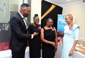 Education and Youth Minister, Hon. Fayval Williams (right), engages in light conversation with (from left) Chief Executive Officer and Registrar, Caribbean Examinations Council (CXC), Dr. Wayne Wesley; Accounts Clerk, CXC, Ava Lettsome; and Beverlyn Henry, representing Receptionist at the Council, Arana Thompson. The event was the CXC’s Employee Appreciation Awards ceremony on December 16 at the Courtleigh Hotel, Kingston. 