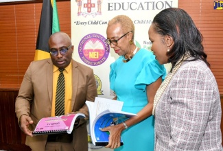 Minister of Education and Youth, Hon. Fayval Williams (centre); Chief Education Officer (Acting) in the Ministry, Dr. Kasan Troupe (right) and President-elect, Jamaica Teachers’ Association (JTA), Leighton Johnson, look at the Civics Curriculum for various grades, which has been reintroduced in the National Standards Curriculum. The launch of the programme was held at the Ministry in Kingston on Tuesday (December 13). 