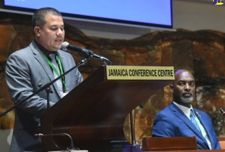 Minister without Portfolio in the Ministry of Economic Growth and Job Creation, Senator the Hon. Matthew Samuda, addresses the inaugural staging of the Forestry Department’s National Forestry Conference held at the Jamaica Conference Centre in downtown Kingston on Wednesday, December 7. Seated at right is Chief Executive Officer of the Forestry Department and Conservator of Forests, Ainsley Henry.