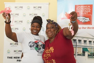 Sisters, Jacinth (left) and Carla Johnson (right) show off the keys to their new homes in Seville Heights, St Ann, that were officially handed over to them by Prime Minister, the Most Hon Andrew Holness, on Monday (December 19), under the New Social Housing Programme (NSHP).