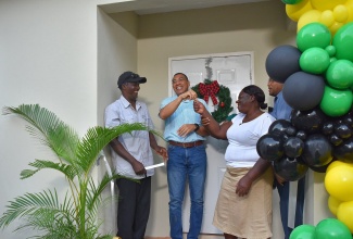 Prime Minister, the Most Hon. Andrew Holness (second left), shares a light moment with  Yvonne and Telford  Mitchell (left), as he hands over the key to the couple’s  new home in Lancaster, Manchester on Friday (Dec. 16). The one-bedroom unit was built under the New Social Housing Programme (NSHP). Partially hidden at right is Member of Parliament for Manchester Southern, Robert Chin. 