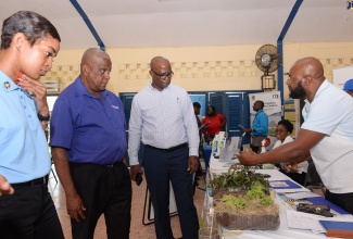 State Minister in the Ministry of Agriculture and Fisheries, Hon. Franklyn Witter (second left), is shown a display at the Rural Agricultural Development Authority’s (RADA) booth by RADA Land Management Officer, Gabbidon Lebert (right), during a World Soil Day event at the Ebony Park HEART Academy in Clarendon, on Wednesday (December 5). Others (from left) are Programme Management and Monitoring Specialist, Food and Agriculture Organization (FAO), Jhannel Tomlinson, and Chief Technical Director in the Agriculture Ministry, Orville Palmer. 