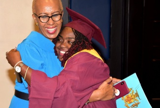 Minister of Education and Youth, Hon. Fayval Williams (left), shares a congratulatory hug with Shanna-Kaye Ferguson, who is a newly commissioned Parent Mentor under the National Parenting Support Commission (NPSC) mentoring programme. The graduation ceremony was held on November 29 at the Jamaica Pegasus Hotel in New Kingston.