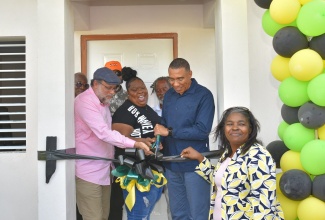 Prime Minister, the Most Hon. Andrew Holness (second right), cuts the ribbon during a ceremony to handover a $7 million three-bedroom house to resident of Hopeful Village in St. Andrew, Thia Jones, recently. The unit was constructed under the Government’s New Social Housing Programme (NSHP). Others (from left) are Opposition Leader and Member of Parliament, St. Andrew South, Mark Golding, and Chairperson, NSHP Oversight Committee, Judith Robb Walters. The NSHP comprises three components – the provision of indigent housing, which will see 315 housing units (five for each of the 63 constituencies) constructed per annum; relocation of vulnerable communities, which will give priority to persons in imminent danger; and the upgrading of tenement yards (one per constituency).