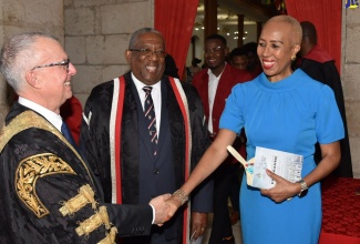 Minister of Education and Youth, Hon. Fayval Williams (right), shakes hands with Chancellor, University of the West Indies (UWI), Robert Bermudez (left), after the Interfaith Convocation Service held at the University Chapel,  St. Andrew, on Sunday (December 8). Looking on is Pro-Vice Chancellor and Principal, UWI, Professor Dale Webber. 