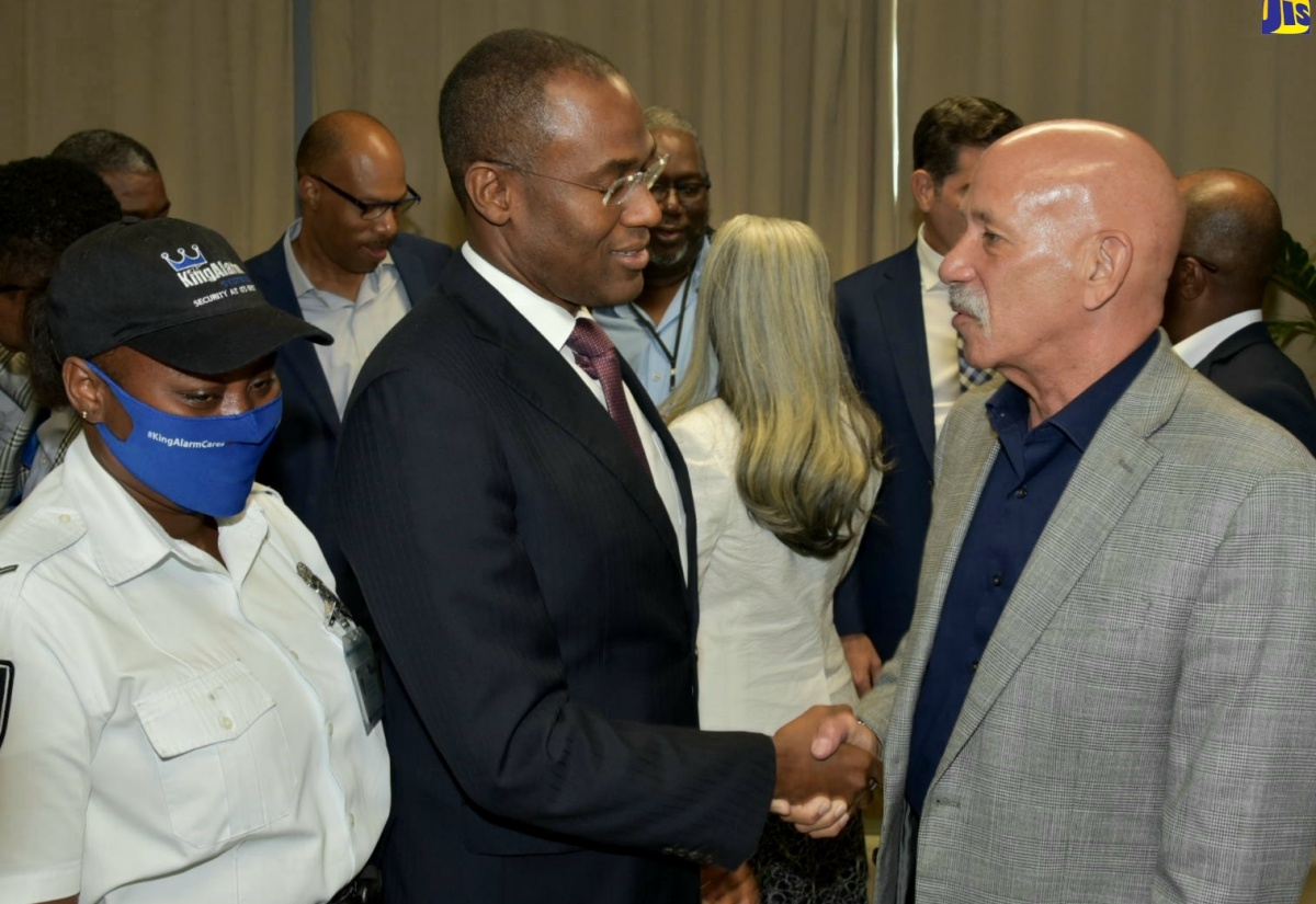 Minister of Finance and the Public Service, Dr. the Hon. Nigel Clarke (centre), greets Director of Operations, Guardsman Group, Commander George Overton, during security industry stakeholder meeting at the Ministry of Foreign Affairs and Foreign Trade in downtown Kingston, on January 19. At left is security officer attached to King Alarm Limited, Kayal Reid.