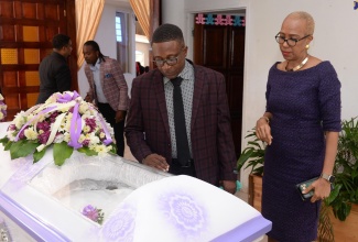 Minister of Education and Youth, Hon. Fayval Williams (right), views the body of Retired Educator, Rev. Dr. Millicent McLean, during a service held at the Portmore Holiness Christian Church in St. Catherine on Thursday (December 5). With the Minister is Dr. McLean’s nephew, Dane Hudson.