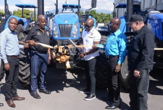 Minister of Agriculture and Fisheries, Hon. Pearnel Charles Jr (centre) and State Minister, Hon. Franklin Witter (second left), lead a ribbon-cutting exercise during Tuesday’s (January 17) handover of six farm tractors, valued at approximately $49.7 million, to the Rural Agricultural Development Authority (RADA). Joining them are (from left) Chief Technical Director in the Ministry, Courtney Cole; Acting CEO, RADA, Winston Simpson and Vice Chairman, RADA Board of Directors, Richard King. 