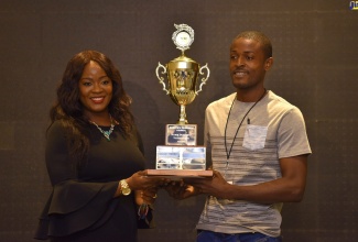 Executive Director, Scientific Research Council (SRC), Dr. Charah Watson (left), presents the 2022 Young Scientist/Technologist Award to University of the West Indies (UWI) Chemistry Lecturer, Dr. Peter Nelson.