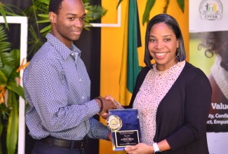 Chief Protection Specialist, UNICEF Jamaica, Dr. Charlene Coore Desai, presents a plaque to Anthony Brown, who copped five subjects in the 2022 Caribbean Secondary Education Certificate (CSEC) examination, during the Child Protection and Family Services Agency (CPFSA) educational achievement awards ceremony, at the Terra Nova All-Suite Hotel in St. Andrew, on January 26. During the ceremony, 39 young persons in State care who attained four or more subjects in the 2022 sitting of the CSEC and Caribbean Advanced Proficiency Examination (CAPE) tests were recognised for their performance. 