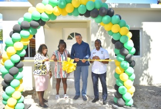 Prime Minister, the Most Hon. Andrew Holness (second right) cuts the ribbon to officially hand over a new three-bedroom house in Rosemary Castle, St. Catherine to Moveta Clarke (second left) on Wednesday (Jan. 25). The house was constructed at a cost of $6.5 million under the New Social Housing Programme (NSHP).
Sharing the moment (from left) are Chairperson for the Oversight Committee, NSHP, Judith Robb Walters, and Member of Parliament, St. Catherine East Central, Hon. Alando Terrelonge. 

