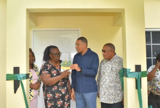 Prime Minister, the Most Hon. Andrew Holness (second right) hands over the keys to a newly built three-bedroom house to beneficiary, Judith Noble (second left), during a ribbon cutting ceremony held in Callaloo Mews on January 25. The unit was built under the New Social Housing Programme (NSHP) at a cost of approximately $5.4 million. Others looking on (from left) are Chairperson, Oversight Committee, NSHP,  Judith Robb Walters and Member of Parliament, St. Andrew Western, Anthony Hylton. 