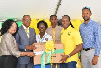 Minister of State in the Ministry of Culture, Gender, Entertainment and Sport, Hon. Alando Terrelonge (second right), presents desktop computers to Principal of the Guy’s Hill High School in St. Catherine, Cecil Donald (second left), at a ceremony held at the Jamaica Anti-Doping Commission (JADCO) offices on Ballater Avenue in St. Andrew, on February 1.   Others (from left) are JADCO’s Executive Director, June Spencer Jarrett; students at the school, Ajoni Murphy and Shanique Neil, and the institution’s Coach, Andrew-Hugh Murphy.