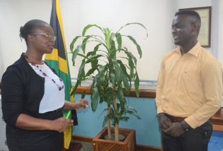 Business and Entrepreneurship Development Manager at the Jamaica 4-H Clubs, Villet Kelly-Bennett (left), speaking with cattle farmer of Colley Mountain, Manchester, Okeito Thompson, who was the recipient of the Prime Minister’s Youth Award for Agriculture in 2020.