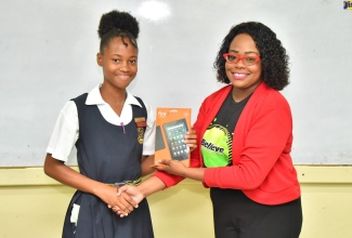 Chief Executive Officer and Founder, Young Scholar Inc, Shanese Watson, presents a tablet to Kingston Technical High School student, Shinay Walker at a ‘Kids Tech’ forum held recently at the Denham Town High School in Kingston. The event was organised by the Ministry of National Security’s Citizen Security Secretariat in collaboration with the Ministry of Education and Youth.