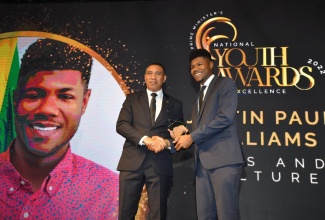 Prime Minister, the Most Hon. Andrew Holness (left), presents the award in the category of arts and culture to Justin Paul Williams during the Prime Minister’s Youth Awards for Excellence 2022, which was held Saturday evening (Feb.4), on the lawns of Jamaica House.