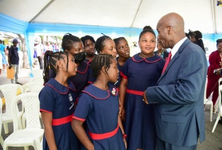 Custos of Kingston, the Hon. Steadman Fuller (right) interacts with students from Allman Town Primary School at the Legal Aid Council’s Justice Fair held at Justice Square, King Street, Downtown Kingston on March 17.