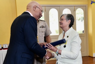 Governor-General, His Excellency the Most Hon. Sir Patrick Allen (left), presents a citation to former Custos for Manchester, Sally Porteous during the Governor- General’s Medal of Honour presentation ceremony and luncheon for current and former Custodes held on Tuesday (March 7) at King’s House.