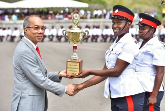 Deputy Prime Minister and Minister of National Security, Hon. Dr. Horace Chang (left), presents the trophy for Highest Mark Obtained from the Jamaica Constabulary Force’s Batches 143 and 144 to Woman Constable Racquel Russell. Looking on is Woman Constable Shevel Lee, who was also awarded in the same category. The presentation was made during Tuesday’s (February 28) Passing Out Parade Ceremony for 282 trainee constables at the National Police College of Jamaica (NPCJ) in St. Catherine. 