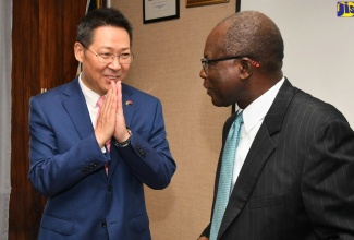 Minister without Portfolio in the Ministry of Economic Growth and Job Creation, Hon. Everald Warmington (right), exchanges greetings with Chinese Ambassador to Jamaica , His Excellency Chen Daojiang, during a courtesy call at the National Works Agency (NWA) in Kingston on March 28.