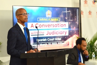 President of the Court of Appeal, Hon. Justice Patrick Brooks (left), addresses journalists at a ‘Conversation with the Judiciary’ forum,  held at the Spanish Court Hotel in Kingston, on March 10. At right is Chief Court Statistician, Dr. Dernato Dennis. 