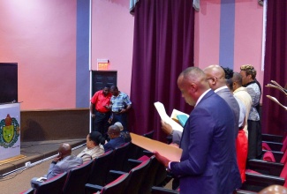 Eighteen new Justices of the Peace (JPs) for Manchester take the oath of office during a commissioning ceremony held on Thursday (March 30) at Church Teachers’ College in the parish. Custos Rotulorum of Manchester, Lt. Col. Hon. Garfield Green (left, at podium) presides over the ceremony.