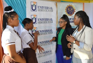 Corporate Planner Universal Service Fund (USF), Nepatra Bennett (right) and Programme Manager, Jamaica Technology and Digital Alliance, Alexia Beckford (second right), engages with President of the USF’s Information and Communication Technology (ICT) Club at Central High School, Sania Smith (second left), and Treasurer Rihanna Bennett.  Occasion was the recent launch of the club at the school in Clarendon.