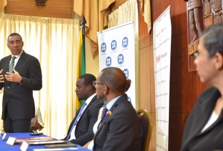 Prime Minister, the Most Hon. Andrew Holness, addressing a Memorandum of Understanding (MOU) Signing Ceremony between the Victoria Mutual (VM) Group, VM Foundation and the National Land Agency (NLA) at Jamaica House recently. Others (from left, seated) are Senior Director, Land Administration and Management (Acting), NLA, Nickoy Young; Chief Executive Officer (CEO), VM Foundation, Samantha Charles; President and CEO, VM Group, Courtney Campbell; CEO and Commissioner of Lands, NLA, Cherise Walcott. 