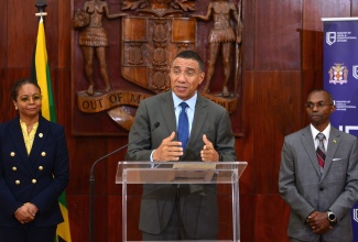 Prime Minister, the Most Hon. Andrew Holness (at the podium) addressing a press conference to announce the members of the Constitutional Reform Committee (CRC) at Jamaica House in St. Andrew on March 22. He is flanked by committee co-chairs Minister of Legal and Constitutional Affairs, Hon. Marlene Malahoo Forte (left) and Ambassador Rocky Meade.
