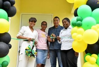 Prime Minister, the Most Hon. Andrew Holness (second right), is joined by (from left) Member of Parliament, St. Ann South Eastern, Lisa Hanna; New Social Housing Programme (NSHP) beneficiary, Stacey Roberts; and Chair, Housing, Opportunity, Production and Employment (HOPE) Project Oversight Committee, Judith Robb-Walters, in cutting the ribbon to officially handover a one-bedroom unit, built under the NSHP in York District, Bensonton, St. Ann, on Friday (April 21). 